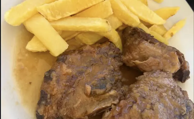 Carne guisada con salsa y patatas fritas
