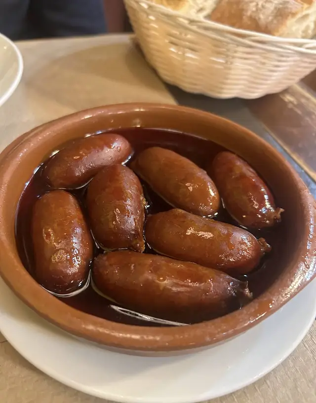 Cazuela con chorizos pequeños en salsa