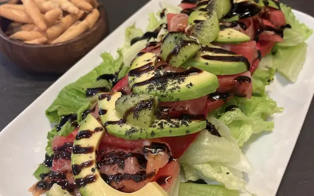Ensalada con lechuga, aguacate, kiwi y tomate aliñada con crema de vinagre