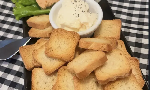 Tostas de pan en una bandeja con una crema para untar